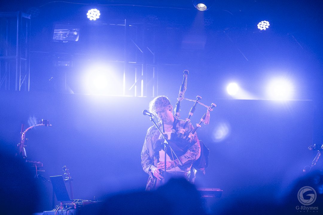 Multi-instrumentalist on bagpipes under blue light, Midtown Ballroom, Bend